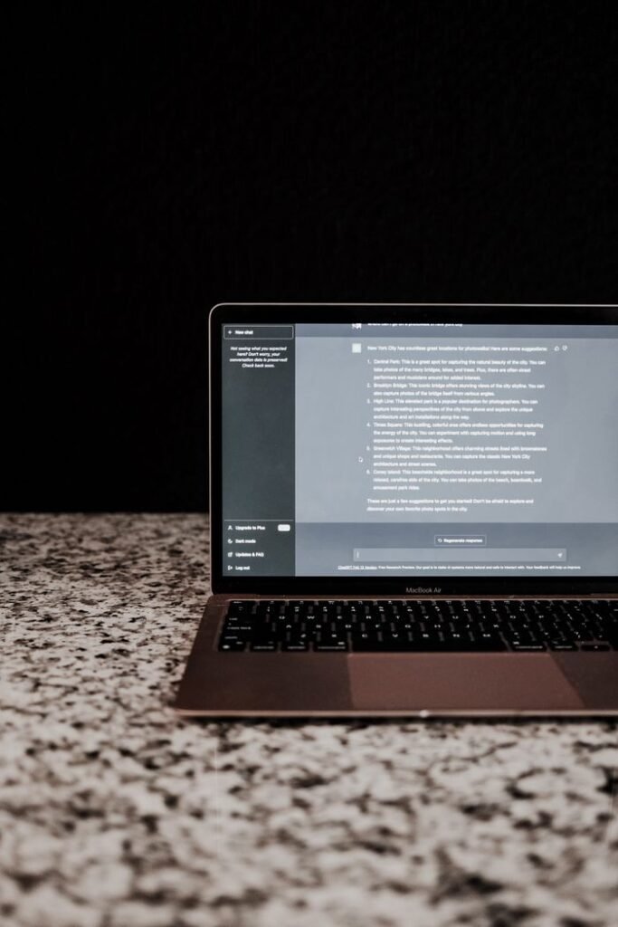 Modern laptop displayed on a granite countertop with a dark, minimalistic backdrop.